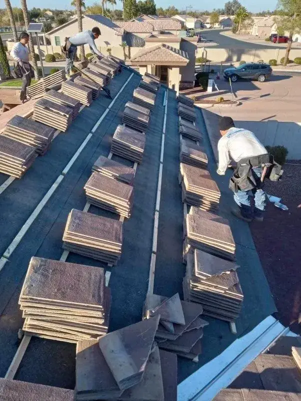 Sundance roofer with clipboard inspecting a tile roof at golden hour