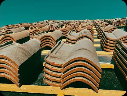 New concrete roof tiles stacked on battens mid-installation